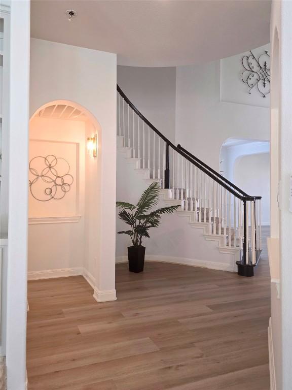 10303 Spicewood Pkwy, Austin, TX 78750 - staircase featuring wood finished floors and arched walkways