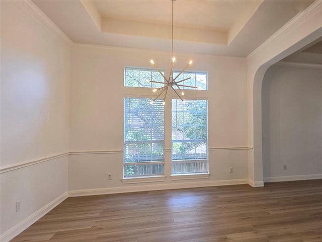 10303 Spicewood Pkwy, Austin, TX 78750 - empty room with a tray ceiling, a chandelier, arched walkways, and wood finished floors