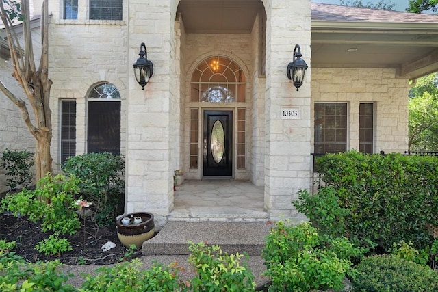 10303 Spicewood Pkwy, Austin, TX 78750 - doorway to property with stone siding, roof with shingles, and a porch