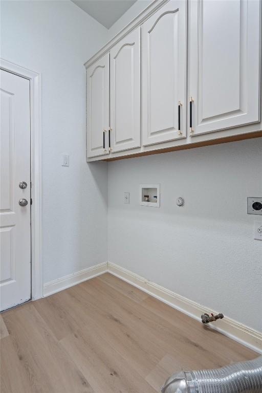 10303 Spicewood Pkwy, Austin, TX 78750 - washroom with hookup for an electric dryer, cabinet space, hookup for a gas dryer, light wood-style floors, and washer hookup