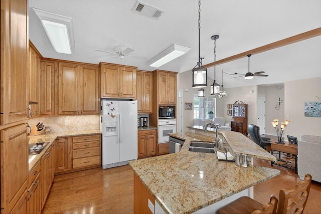 127 W Stonecastle Dr, Granite Shoals, TX 78654 - kitchen with black appliances, a ceiling fan, a breakfast bar area, light wood finished floors, and vaulted ceiling