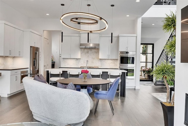 6702 Adeline Way Unit 34, Austin, TX 78746 - dining room featuring wood finished floors, recessed lighting, and a high ceiling