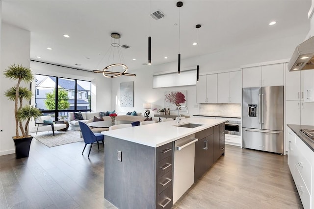 6702 Adeline Way Unit 34, Austin, TX 78746 - kitchen featuring appliances with stainless steel finishes, modern cabinets, light wood-style flooring, and recessed lighting