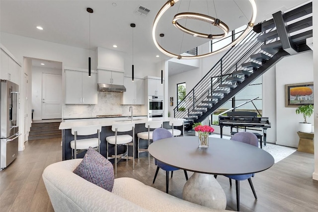 6702 Adeline Way Unit 34, Austin, TX 78746 - dining area featuring stairs, light wood-style flooring, recessed lighting, and a high ceiling