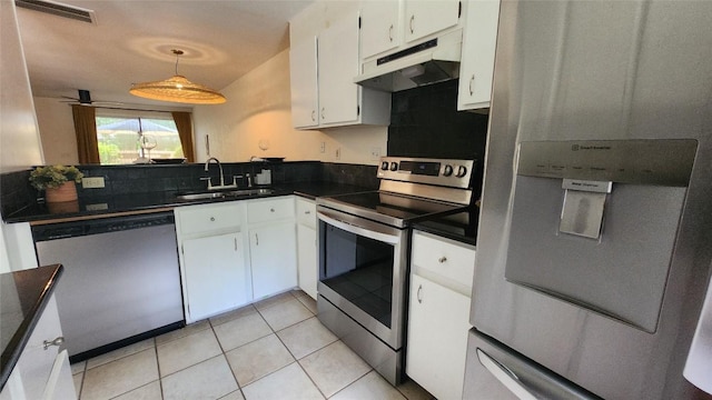 7122 Wood Hollow Dr Unit 41, Austin, TX 78731 - kitchen with appliances with stainless steel finishes, under cabinet range hood, dark countertops, white cabinets, and light tile patterned flooring