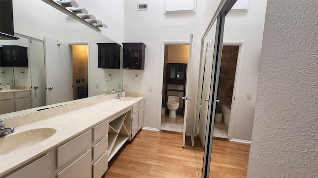 7122 Wood Hollow Dr Unit 41, Austin, TX 78731 - full bathroom with double vanity, wood finished floors, and bathing tub / shower combination