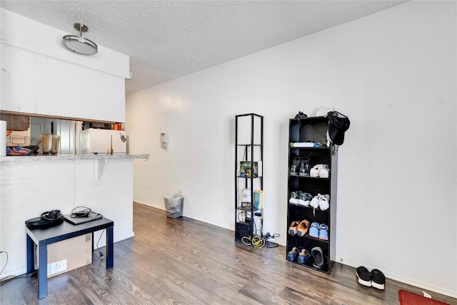 2801 Hemphill Park Unit A102, Austin, TX 78705 - interior space with freestanding refrigerator, dark wood-type flooring, white cabinets, a textured ceiling, and a kitchen bar