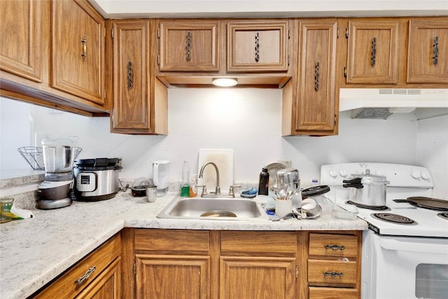 2801 Hemphill Park Unit A102, Austin, TX 78705 - kitchen with under cabinet range hood, white range with electric stovetop, light countertops, and brown cabinetry