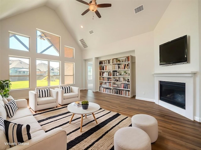 2320 Lucky Ln, Leander, TX 78641 - living room with a ceiling fan, a glass covered fireplace, wood finished floors, healthy amount of natural light, and high vaulted ceiling