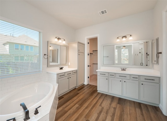 2320 Lucky Ln, Leander, TX 78641 - full bath with a bath, two vanities, and wood finished floors