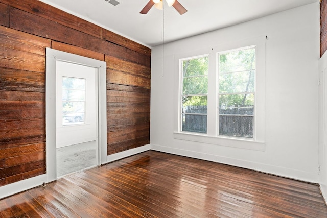 102 S Western Ave, Lampasas, TX 76550 - empty room with ceiling fan, dark wood-type flooring, and wooden walls