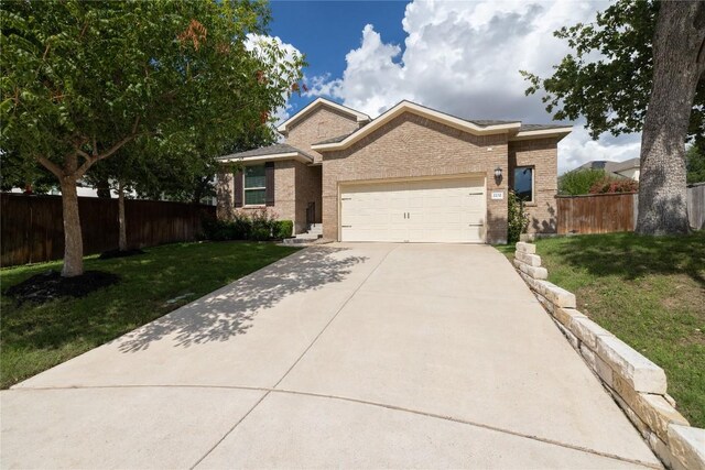 2232 Skippy Cv, Leander, TX 78641 - view of front facade featuring a garage, brick siding, and driveway