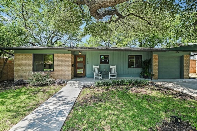 1509 Ridgehaven Dr, Austin, TX 78723 - view of front of property featuring a porch, a garage, brick siding, a front lawn, and concrete driveway