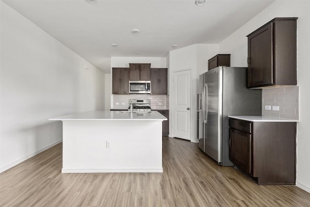 11825 Monterosso Dr, Austin, TX 78754 - kitchen featuring stainless steel appliances, dark brown cabinets, and light wood-type flooring