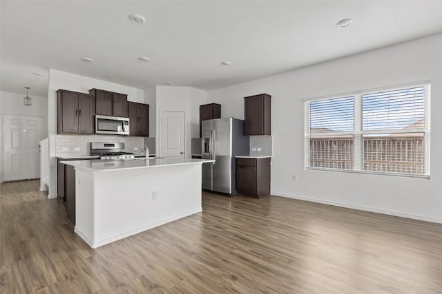 11825 Monterosso Dr, Austin, TX 78754 - kitchen featuring appliances with stainless steel finishes, light wood-type flooring, dark brown cabinets, and light countertops