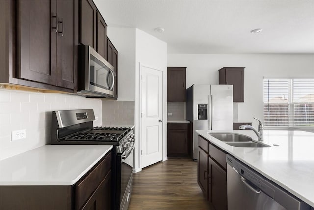 11825 Monterosso Dr, Austin, TX 78754 - kitchen featuring appliances with stainless steel finishes, dark brown cabinetry, light countertops, dark wood finished floors, and decorative backsplash