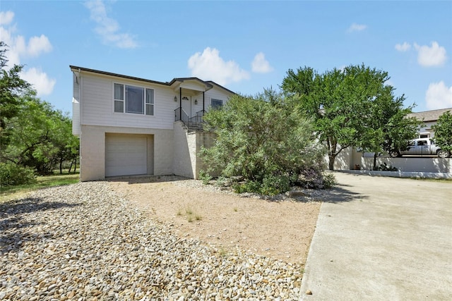 2806 Truman Cv, Lago Vista, TX 78645 - view of front of home featuring driveway, an attached garage, stairway, and stucco siding