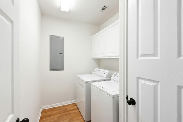 2806 Truman Cv, Lago Vista, TX 78645 - laundry area featuring electric panel, washer and dryer, cabinet space, and light wood finished floors