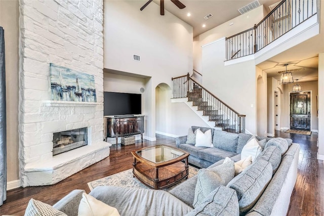 110 Waverly Spire Ct, Austin, TX 78738 - living room featuring arched walkways, stairs, a ceiling fan, wood finished floors, and a fireplace