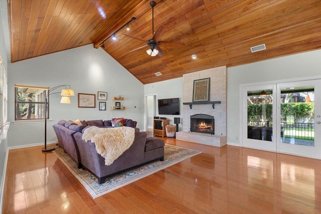 3004 Quail Run Dr, Round Rock, TX 78681 - living area with a wood ceiling with exposed beams, a ceiling fan, plenty of natural light, wood finished floors, and a brick fireplace