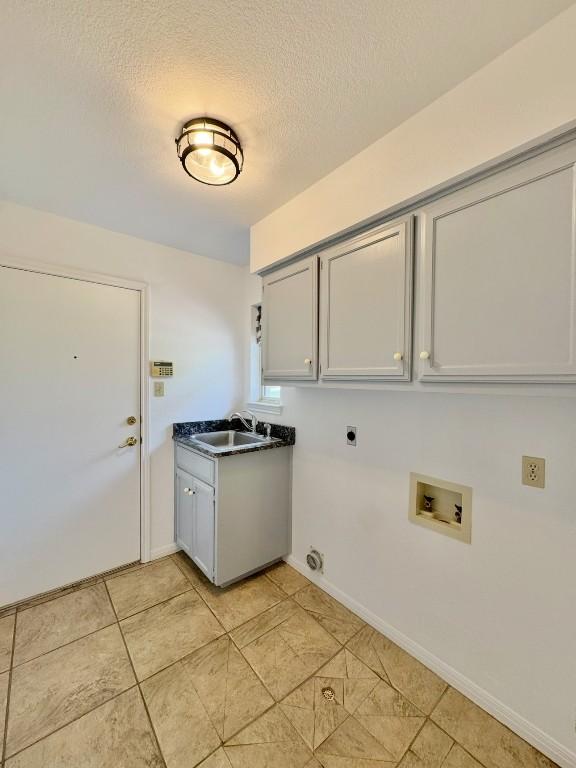 224 Crooked Hollow Dr, Elgin, TX 78621 - washroom with hookup for a washing machine, electric dryer hookup, cabinet space, a textured ceiling, and light tile patterned floors