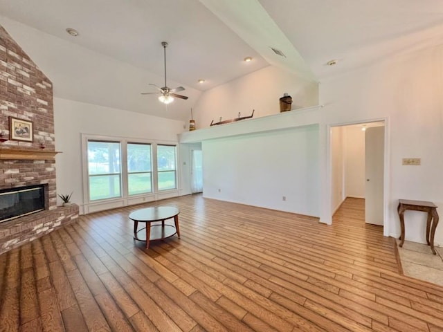 224 Crooked Hollow Dr, Elgin, TX 78621 - unfurnished living room with a brick fireplace, a ceiling fan, high vaulted ceiling, and light wood-style floors