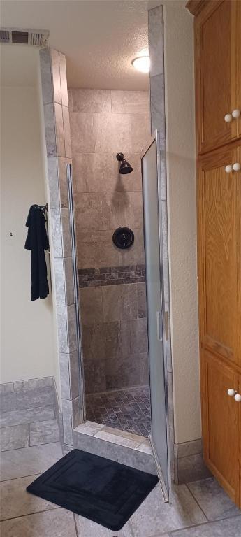 224 Crooked Hollow Dr, Elgin, TX 78621 - bathroom with tiled shower and a textured ceiling