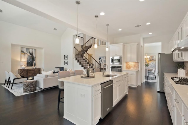 4108 Logan Ridge Dr, Cedar Park, TX 78613 - kitchen featuring appliances with stainless steel finishes, dark wood-style floors, a breakfast bar, white cabinetry, and open floor plan