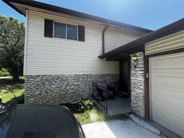 6005 Walnut Hills Dr, Austin, TX 78723 - view of side of property with stone siding and a garage