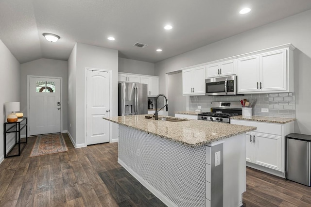 13911 Macquarie Dr, Pflugerville, TX 78660 - kitchen with appliances with stainless steel finishes, a kitchen island with sink, dark wood-type flooring, backsplash, and recessed lighting