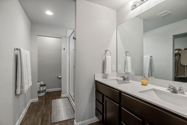 13911 Macquarie Dr, Pflugerville, TX 78660 - full bathroom featuring double vanity, wood finished floors, and a stall shower