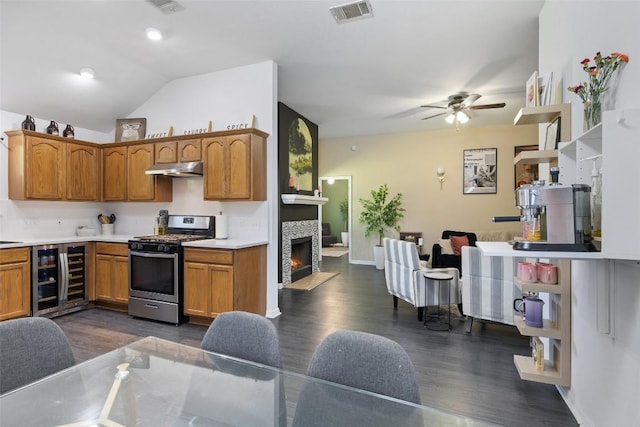 6001 Andross Ct, Hutto, TX 78634 - kitchen with gas stove, wine cooler, ceiling fan, under cabinet range hood, and dark wood finished floors