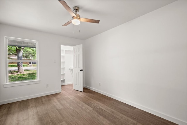 7913 W Gate Blvd Unit A, Austin, TX 78745 - unfurnished bedroom featuring wood finished floors, a spacious closet, a ceiling fan, and a closet
