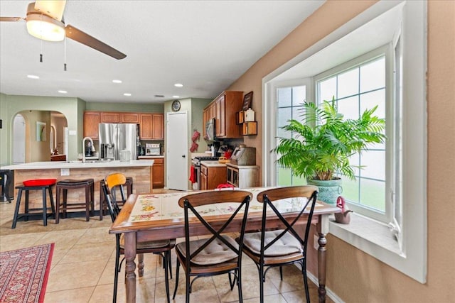 dining room featuring a ceiling fan, recessed lighting, light tile patterned floors, and arched walkways