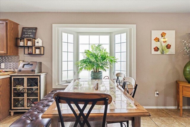 dining room featuring baseboards and light tile patterned flooring
