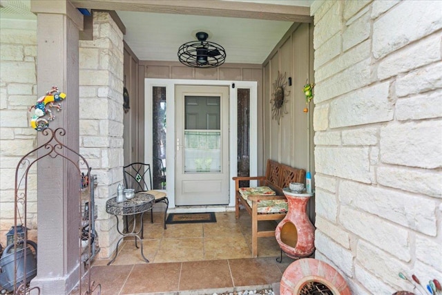 doorway to property with a porch and stone siding
