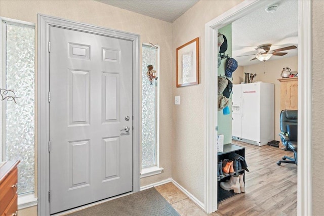 entrance foyer featuring ceiling fan, a textured ceiling, and light wood-style floors