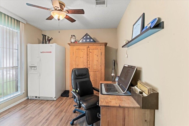 office space with light wood-style floors, a ceiling fan, and healthy amount of natural light