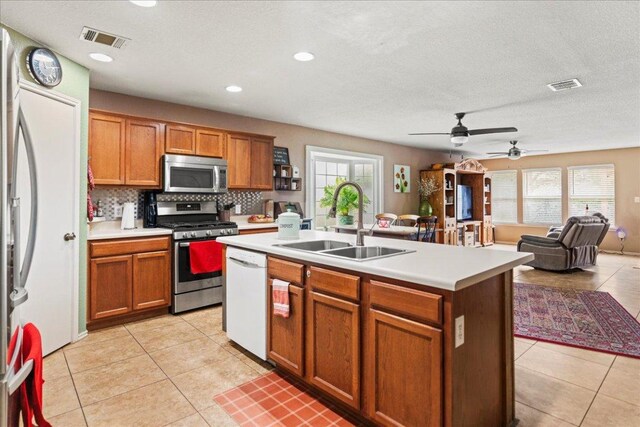kitchen with appliances with stainless steel finishes, light tile patterned floors, light countertops, decorative backsplash, and recessed lighting