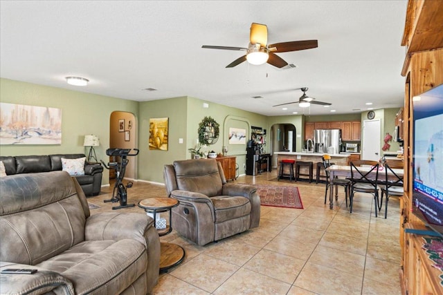 living area with ceiling fan, arched walkways, light tile patterned floors, and recessed lighting