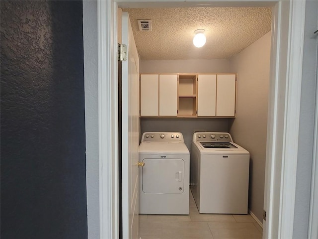 1805 Timber Ridge Dr, Cedar Park, TX 78613 - laundry area featuring separate washer and dryer, cabinet space, light tile patterned floors, and a textured ceiling