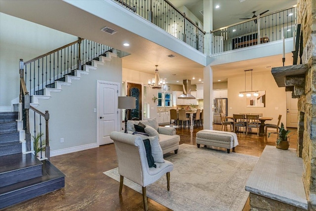 4275 Fm 3405, Georgetown, TX 78633 - living area featuring a high ceiling, a chandelier, stairway, ceiling fan, and concrete flooring