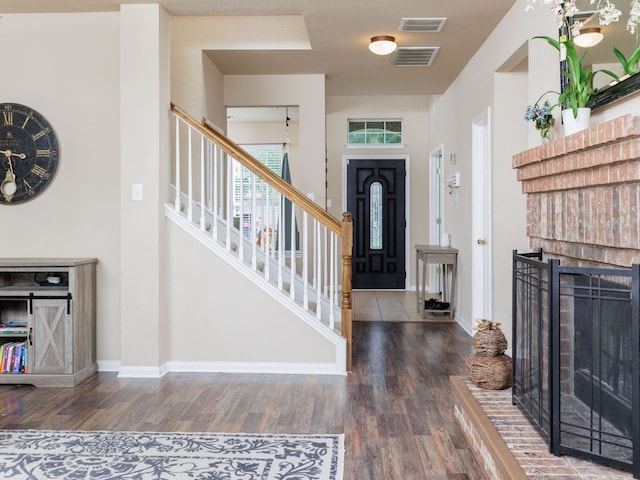 2407 Silver Spur Ln, Leander, TX 78641 - entryway with wood finished floors, stairs, and a brick fireplace