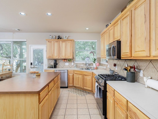 2407 Silver Spur Ln, Leander, TX 78641 - kitchen with appliances with stainless steel finishes, light brown cabinetry, backsplash, recessed lighting, and light tile patterned floors