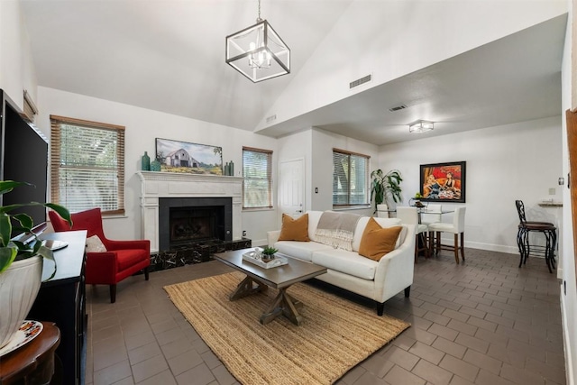 8600 Cima Oak Ln Unit A15, Austin, TX 78759 - living room with a chandelier, high vaulted ceiling, dark tile patterned flooring, and a fireplace with raised hearth