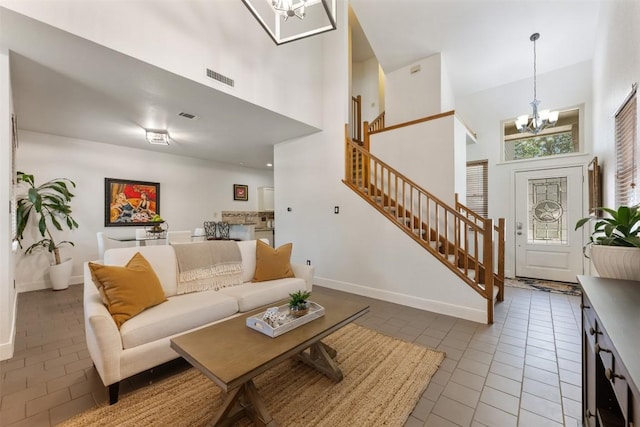 8600 Cima Oak Ln Unit A15, Austin, TX 78759 - living room with a chandelier, a high ceiling, stairs, and tile patterned flooring