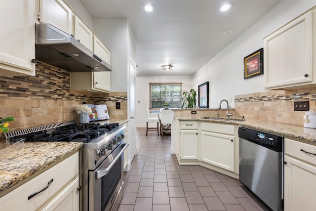 8600 Cima Oak Ln Unit A15, Austin, TX 78759 - kitchen with appliances with stainless steel finishes, under cabinet range hood, dark tile patterned flooring, a peninsula, and tasteful backsplash