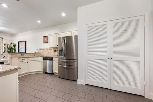 8600 Cima Oak Ln Unit A15, Austin, TX 78759 - kitchen featuring appliances with stainless steel finishes, a peninsula, white cabinets, tile patterned floors, and recessed lighting