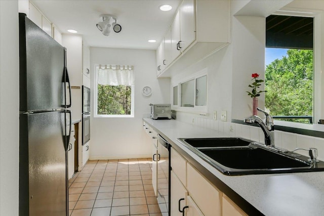 1707 Spyglass Dr Unit 41, Austin, TX 78746 - kitchen with appliances with stainless steel finishes, healthy amount of natural light, light tile patterned floors, recessed lighting, and white cabinets