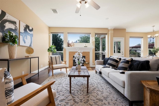 3126 Fiorellino Pl, Cedar Park, TX 78613 - living room featuring wood finished floors, a ceiling fan, a tiled fireplace, and a chandelier